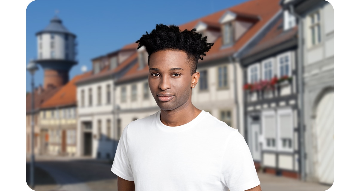 High quality portrait shot of a young man looking up, while the houses with many windows blurred out in the background.
