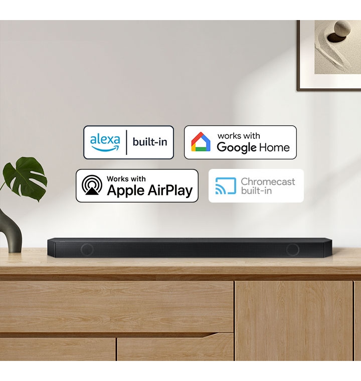 A Samsung Soundbar with logos for Alexa built-in, Works with Google Home, Works with Apple AirPlay and Chromecast built-in.