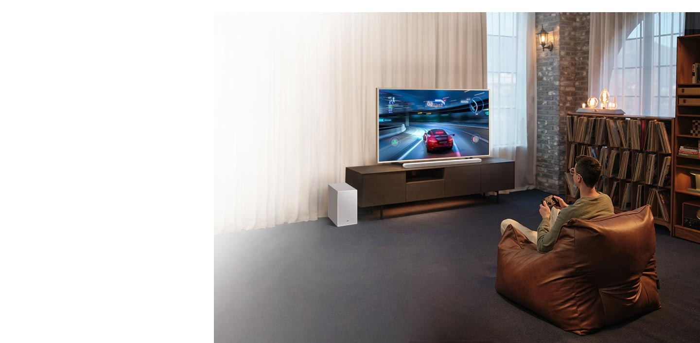 A man enjoys an immersive 3D-like gaming experience with Game Mode Pro on his Samsung Ultra Slim Soundbar.