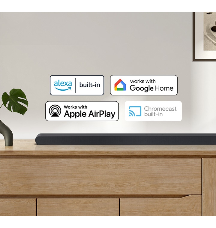 A Samsung Soundbar with logos for Alexa built-in, Works with Google Home, Works with Apple AirPlay and Chromecast built-in.