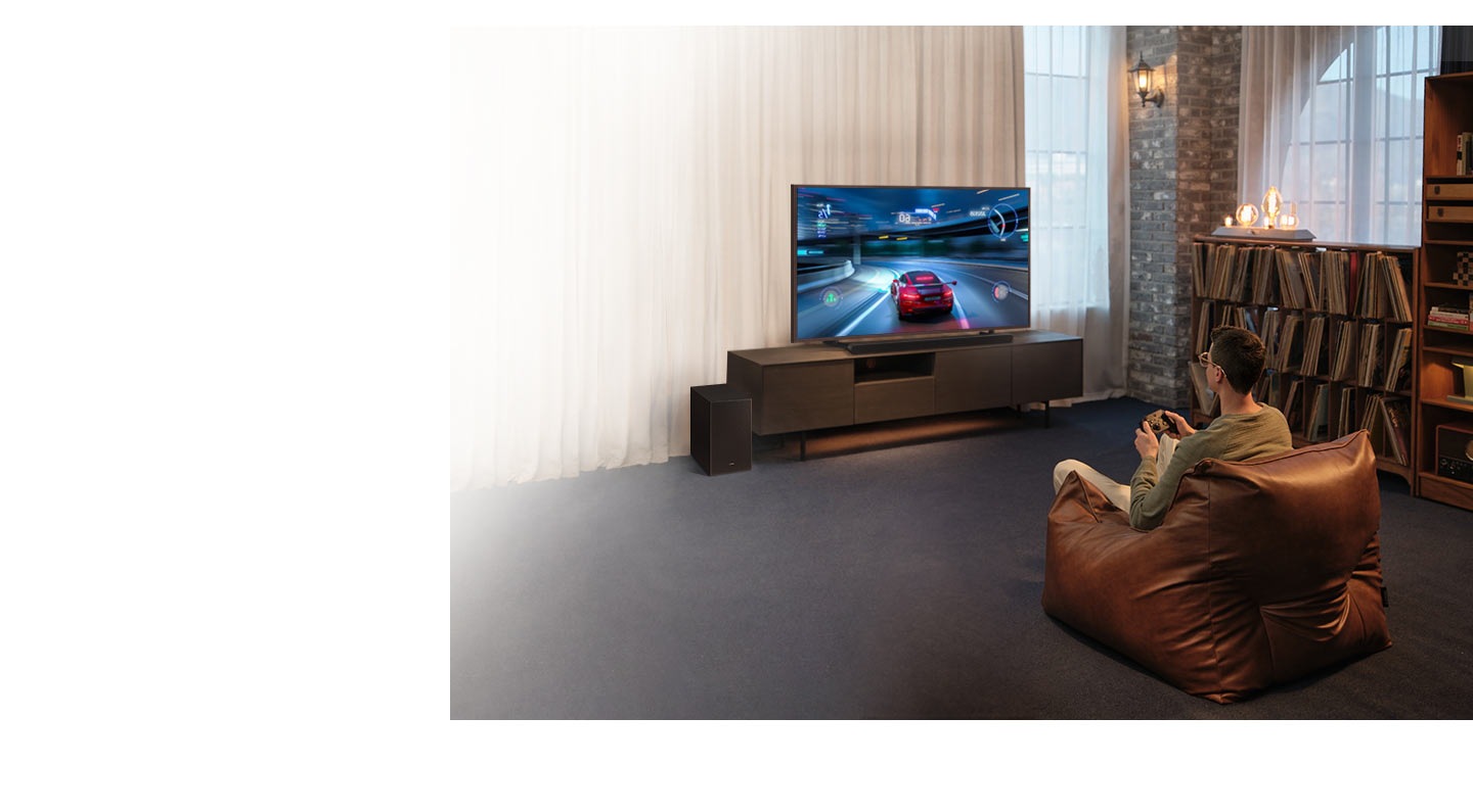 A man enjoys an immersive 3D-like gaming experience with Game Mode Pro on his Samsung Ultra Slim Soundbar.