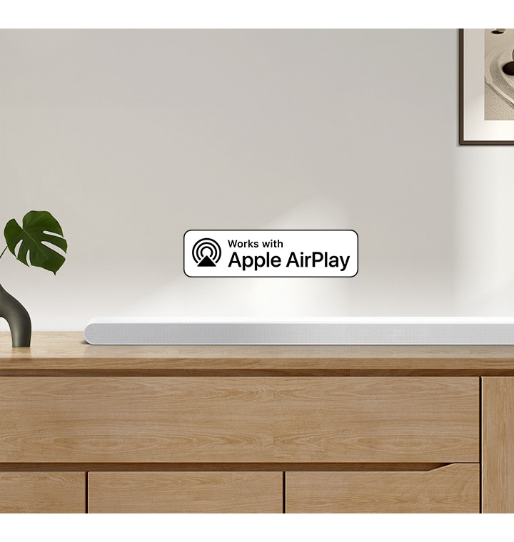 A Samsung Soundbar sits on top of a cabinet, accompanied by a logo for Works with Apple AirPlay.