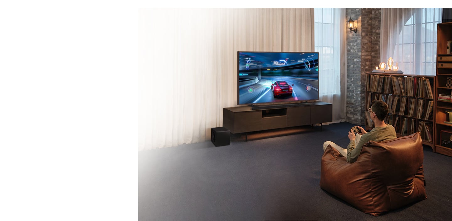 A man enjoys an immersive 3D-like gaming experience with Game Mode Pro on his Samsung Ultra Slim Soundbar.