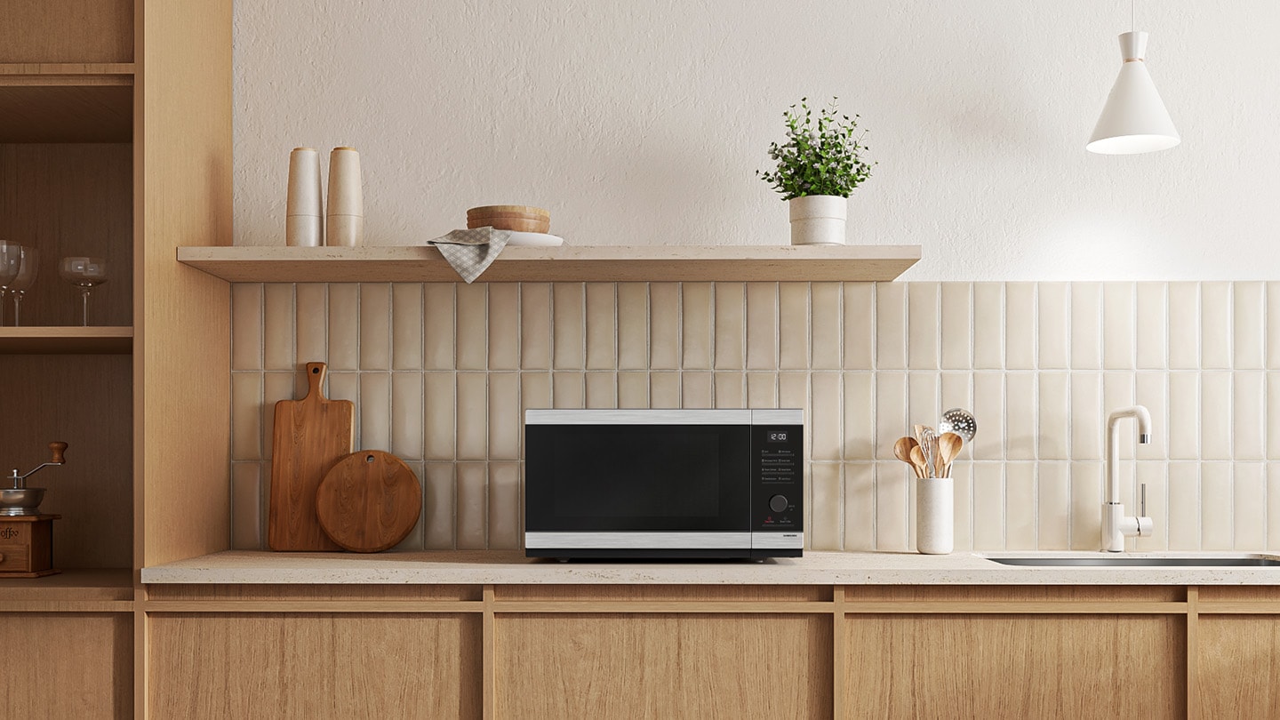 Shows the microwave oven on the counter top of a modern kitchen.