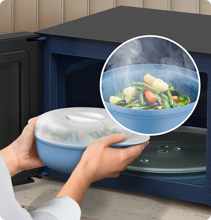 A person is taking a large bowl of steamed mixed vegetables out of an open microwave oven. A close-up shows the steamed vegetables in the bowl.