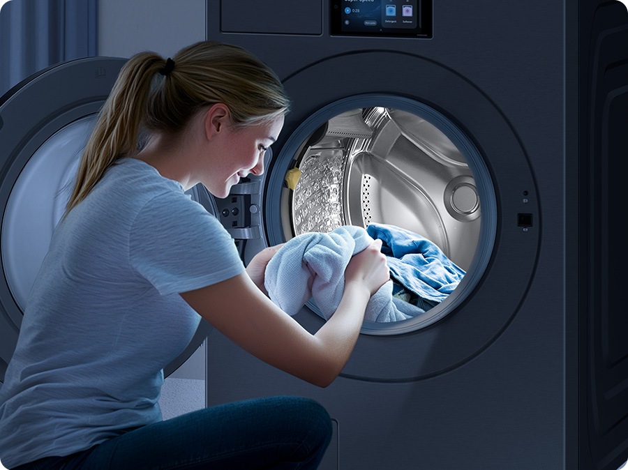 The interior light brightly illuminates the inside of the washer, making it easy for the woman to take out the laundry from the drum.