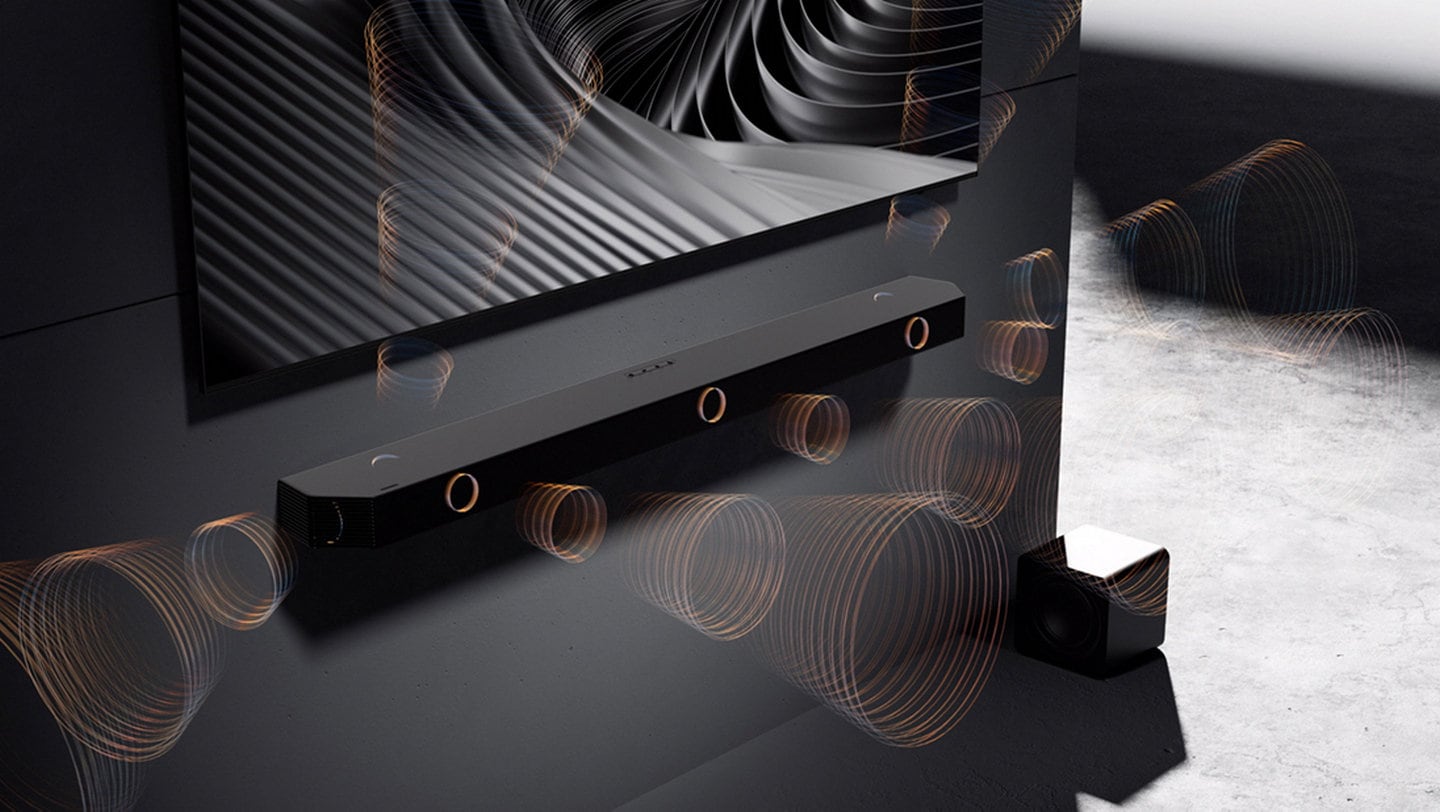 Close-up of Q-Series Soundbar Q800F. Zoom out to Q800F below TV in a room. Q800F inner components show how True 5.1.2ch sound is created. Surround sound pouring from all around. Subwoofer inner components are shown. 6.5-inch active unit with 8-inch passive radiator. Soundwaves play from subwoofer. Soundwaves coming from the soundbar and subwoofer play in various directions to show Wireless Dolby Atmos with Dolby Atmos logo. Cable between TV and soundbar disappears. Immersive sound without an HDMI cable. TV & Soundbar speakers work together in perfect harmony with Q-Symphony. SpaceFit Sound Pro analyzes the room for stunning sound automatically tuned and calibrated for your space. Active Voice Amplifier Pro boosts voices based on outside noise and in-content audio, so you can catch every word without distraction. Adaptive Sound plays sound and dialogue optimized for your content, like Sports, Movie, Speech and Music. Q800F setup with TV. Samsung logo.