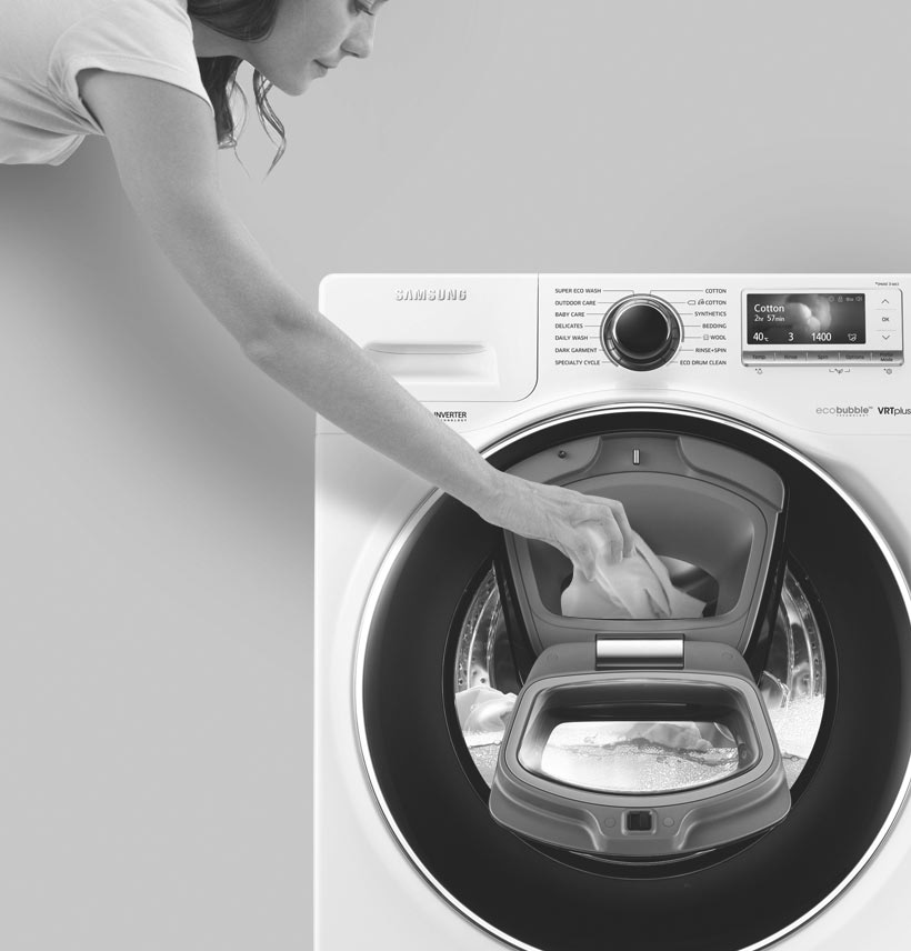 An image showing a woman adding an item to the wash via the Add Door during the rinsing cycle.
