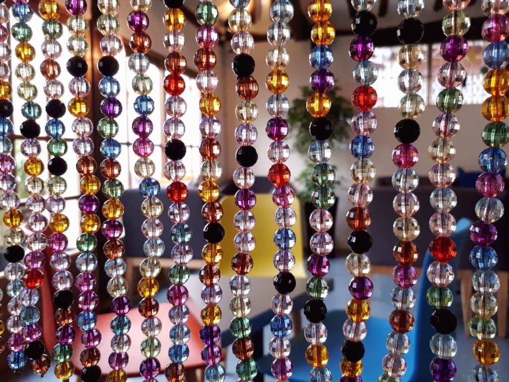 A close up of a hanging coloful bead curtain