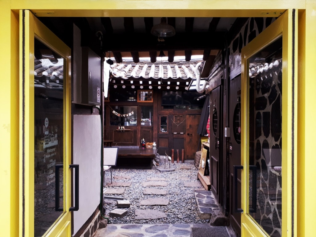 Entrance of a small antique café with yellow doors
