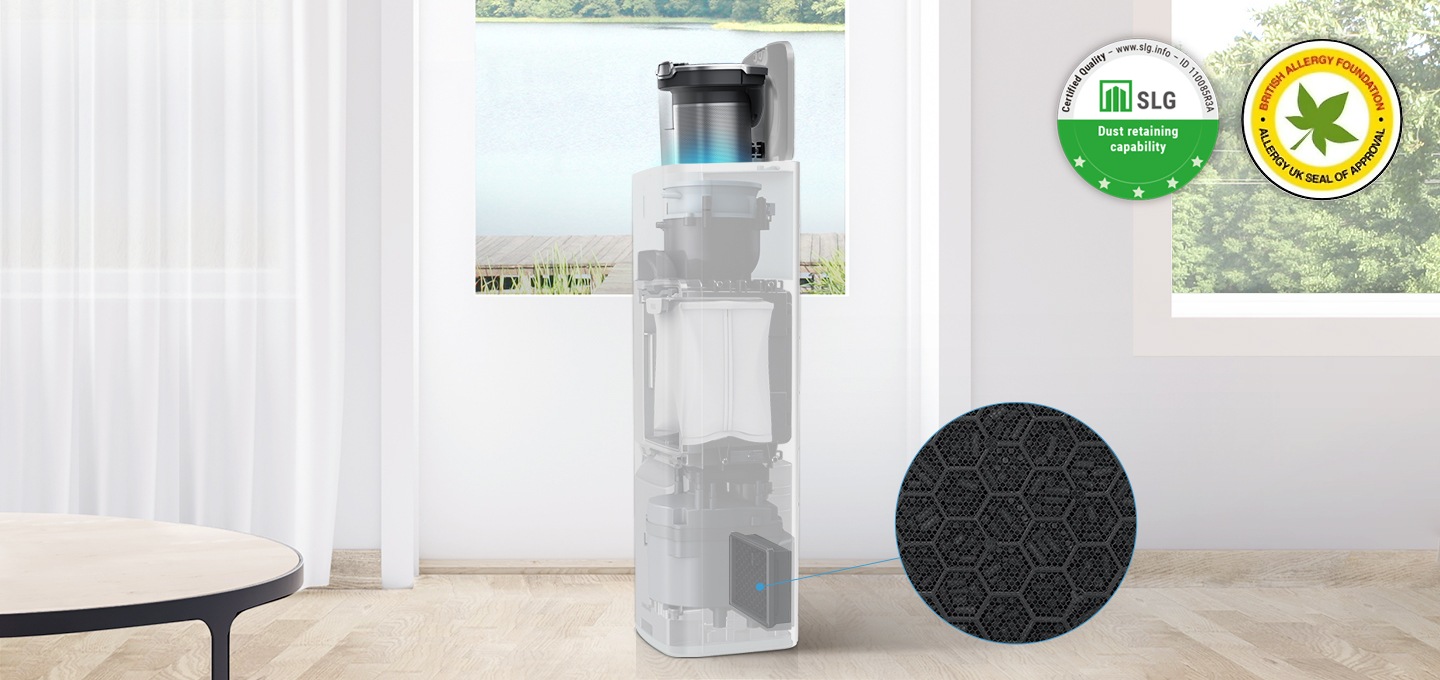 원목 마루가 깔린 거실 뒤에는 하얀 벽이 있고 벽 가운데와 오른쪽에는 호수가 보이는 창문이 있습니다. 창문 가장 왼쪽에는 흰색의 얇은 커튼이 드리워져 있습니다. 이미지 왼쪽 하단에는 원형 테이블이 보이고 이미지 가장 가운데 청정스테이션에 먼지통이 결합되어 있는 모습이 보입니다. 청정스테이션 내부는 투명하게 처리되어 안 쪽 내부 부품이 투명하게 보이는 상태로 가장 하단 청정스테이션용 배기필터 부분을 파란색 선으로 표시 후 확대하여 보여주소 있습니다. 이미지 오른쪽 상단에는 SLG 인증 로고와 BAF 인증 로고가 나란히 나열되어 있습니다.