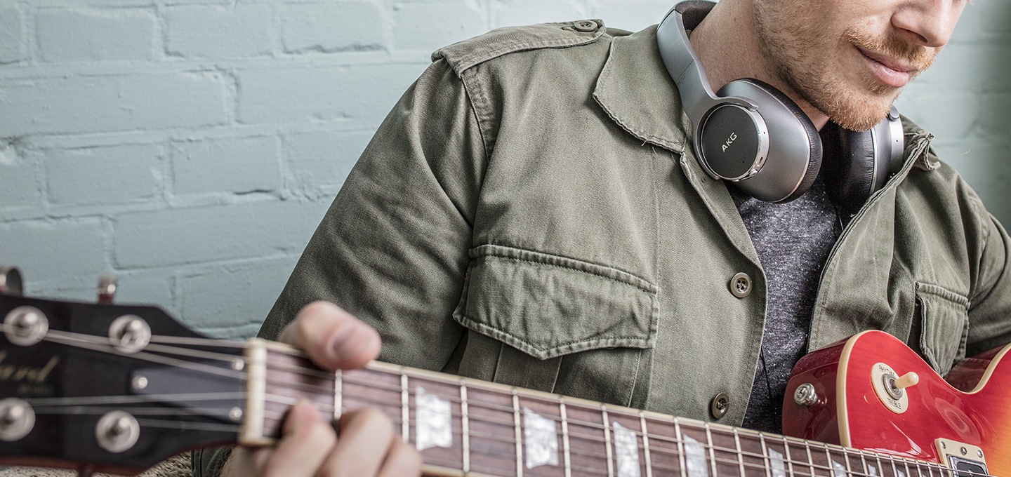 [사용자가 ákg ñ~700ñcm2 를 착용하고 기타를 연주하고 있는 이미지를 볼 수 있습니다.]