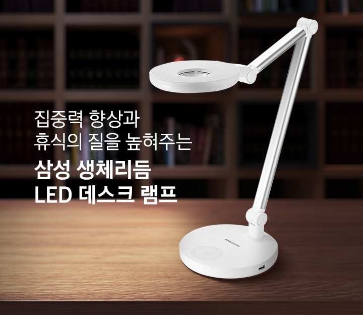 집중력 향상과 휴식의 질을 높혀주는 삼성 생체리듬  LED 데스크 램프입니다. 어두운 서재 책상위에 데스크 램프가 켜져 있습니다.