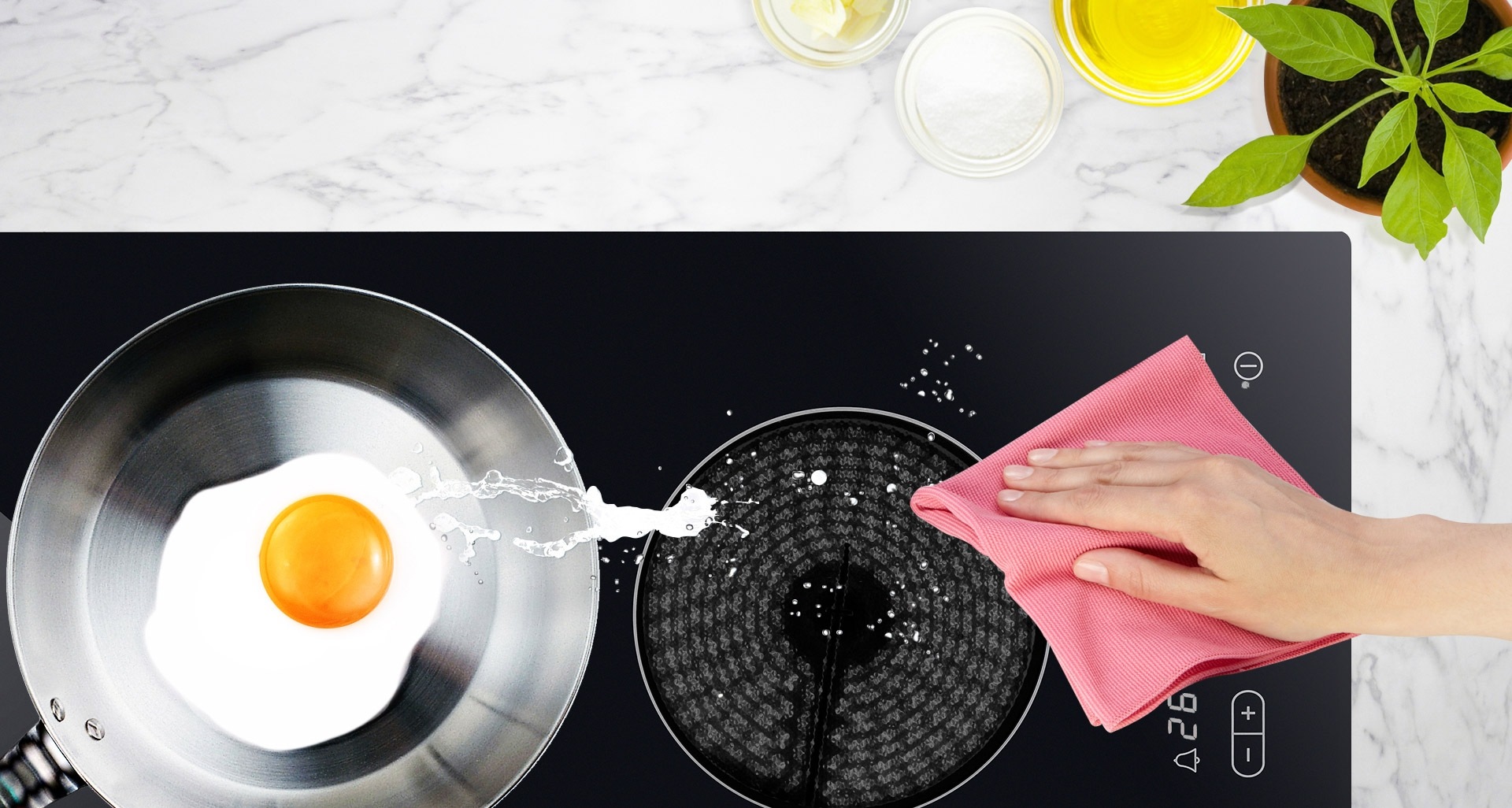 전기레인지 한쪽에는 후라이팬에 계란 요리가 있고 조작부 주변을 행주로 닦아내고 있는 모습입니다.