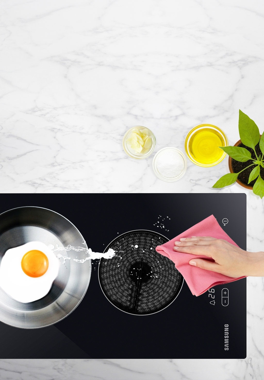 전기레인지 한쪽에는 후라이팬에 계란 요리가 있고 조작부 주변을 행주로 닦아내고 있는 모습입니다.