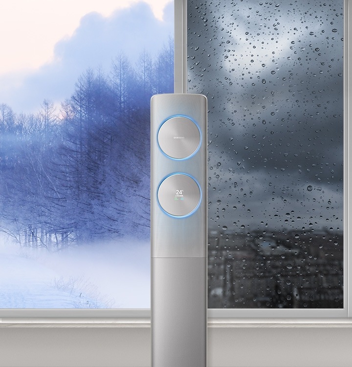 물방울일 맺힌 창문 앞에 있는 에어컨을 보여주고 있습니다.