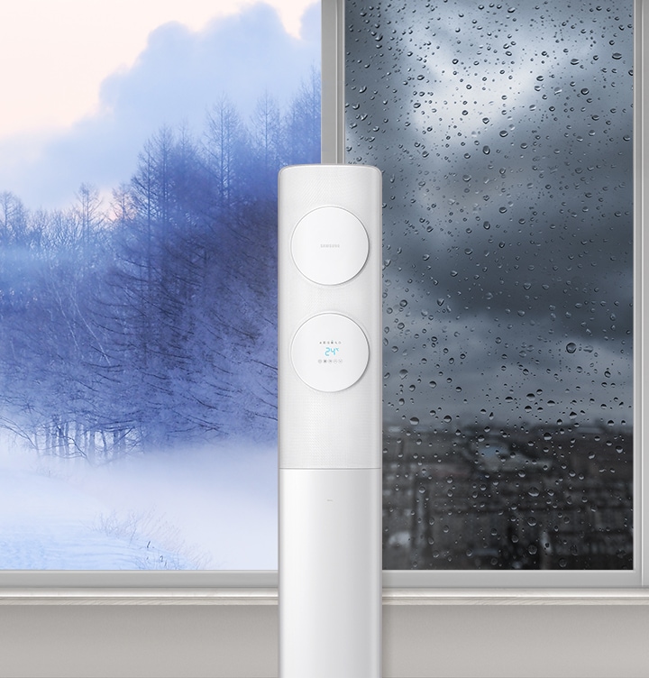 물방울일 맺힌 창문 앞에 있는 에어컨을 보여주고 있습니다.