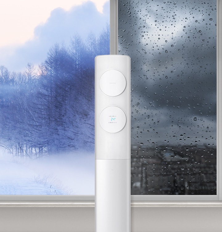 물방울일 맺힌 창문 앞에 있는 에어컨을 보여주고 있습니다.