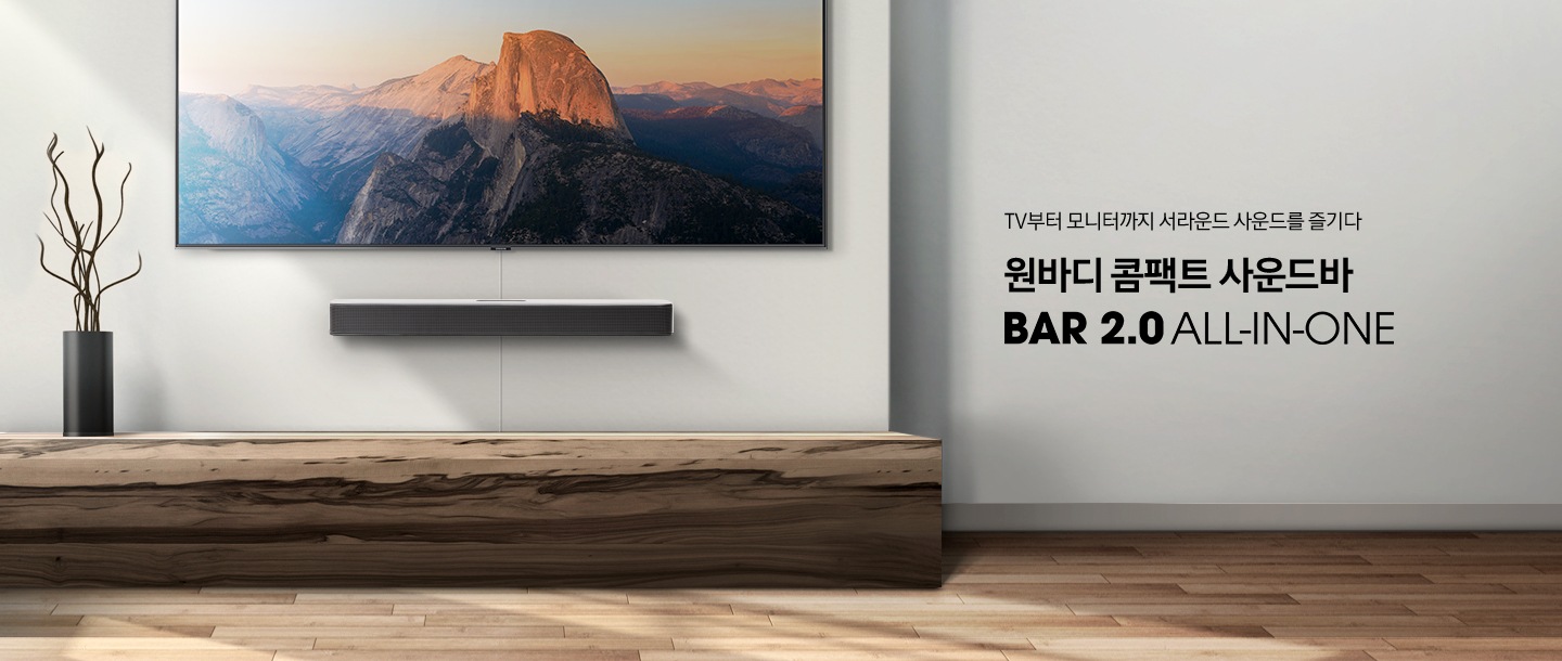 거실 벽면에 벽걸이 TV와 함께 사운드바가 설치되어 있습니다.