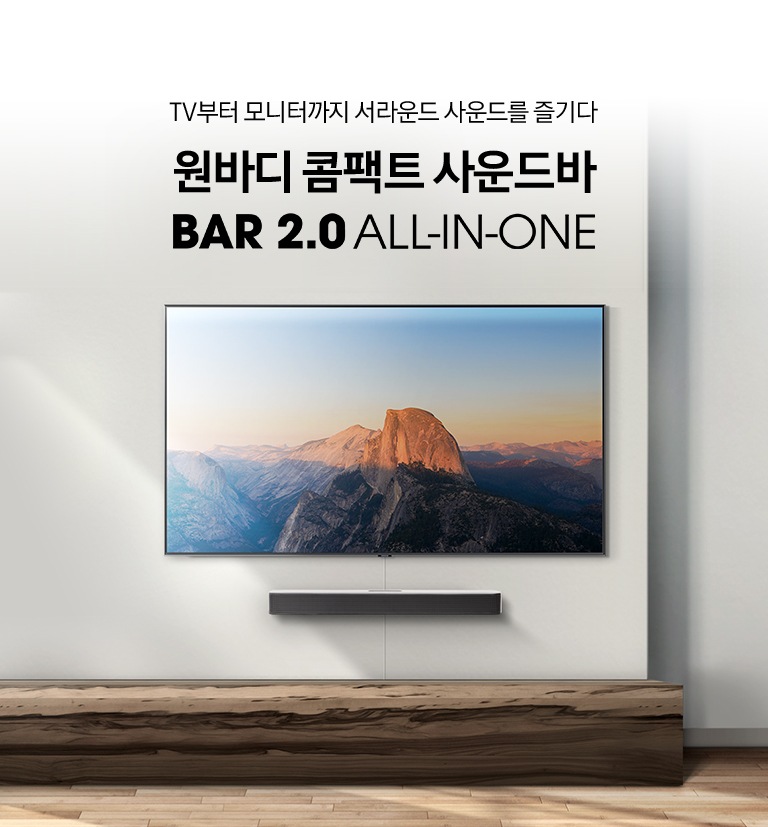 거실 벽면에 벽걸이 TV와 함께 사운드바가 설치되어 있습니다.