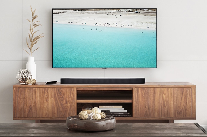 거실 벽면에 벽걸이 TV와 사운드바가 설치되어 있습니다.