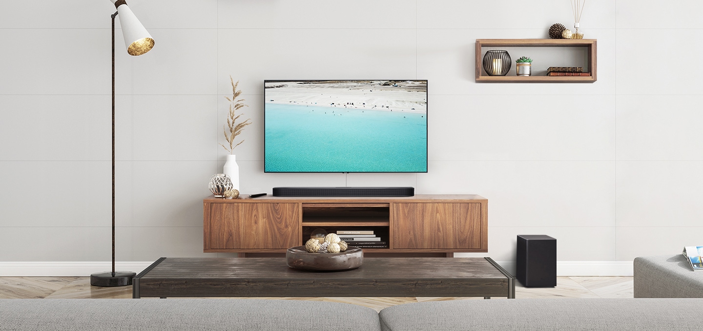 거실 벽면에 벽걸이 TV와 사운드바가 설치되어 있습니다.