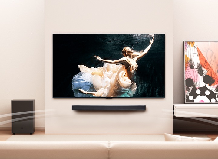 거실 벽면에 벽걸이 TV와 사운드바가 설치되어 있습니다.