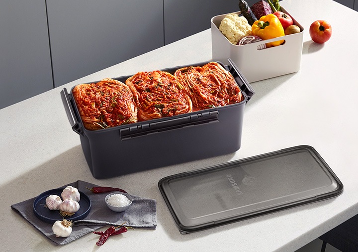 식탁에 토프 김치통에 담긴 김치가 보이고 있습니다.