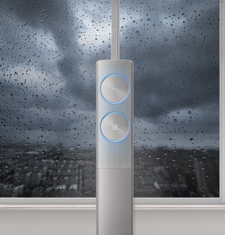 무풍에어컨이 창가 가운데 보여지고, 밖에는 비가 오고 있습니다.