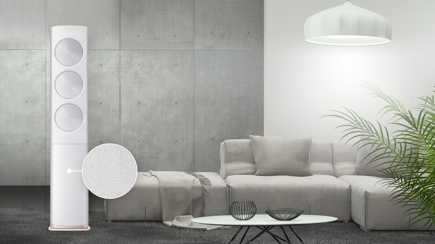 그레이 톤 거실에 조화롭게 놓여진 무풍에어컨이 보여지며, 에어컨 하단 판넬의 골드 톤 패브릭 패턴을 확대하여 보여주고 있습니다.