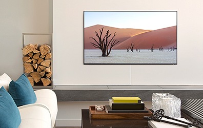 쇼파가 있는 거실에 TV가 벽에 걸려 있습니다.