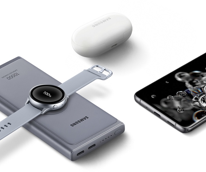 무선충전으로 워치를 충전하고 있으며, 주변에 버즈와 핸드폰이 놓여져 있습니다.