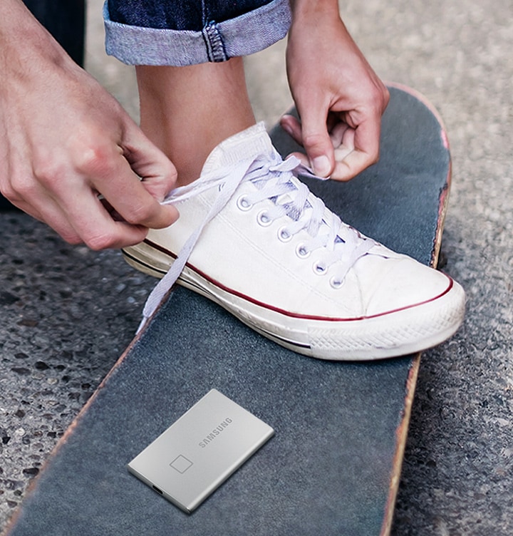 아스팔드 도로 위 스케이트보드 배경에 이미지 상단 부분에는 신발끈 묶는 이미지가 있고 이미지 하단 부분에는 스케이트보드 위에 제품이미지가 올려져있습니다. 