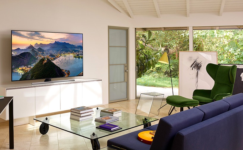 거실에 TV가 설치되어 있는 모습을 보여주고 있고 TV가 선반위에 설치되어 있습니다.