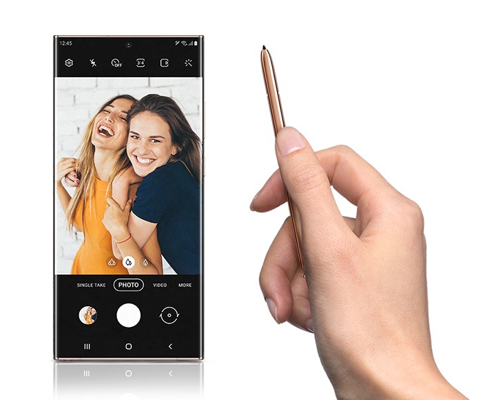 왼쪽에는 갤럭시 스마트폰이 보여지며 찍은 사진을 보여주고 있습니다. 오른쪽에는 오른손으로 S펜을 들고 있으며 갤럭시 스마트폰의 사진을 그리려는 손동작을 하고 있습니다.