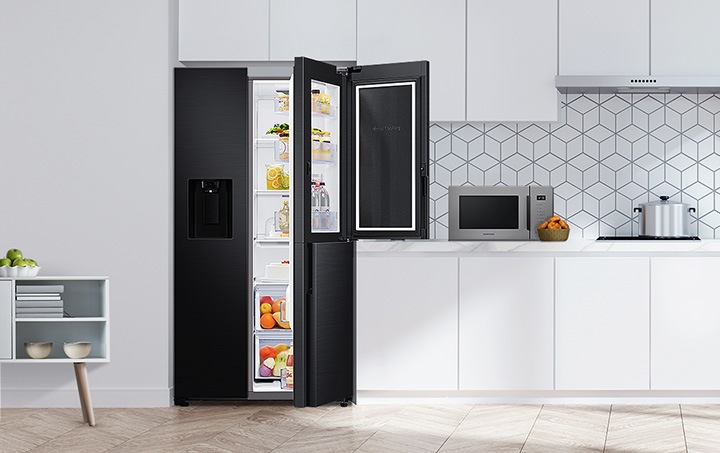 주방을 배경으로 젠틀 블랙 매트 컬러 냉장고 제품 오른쪽 인케이스가 살짝 열려있고 푸드 쇼케이스가 활짝 열려있으며 안에 음식들이 신선하게 채워져있습니다.