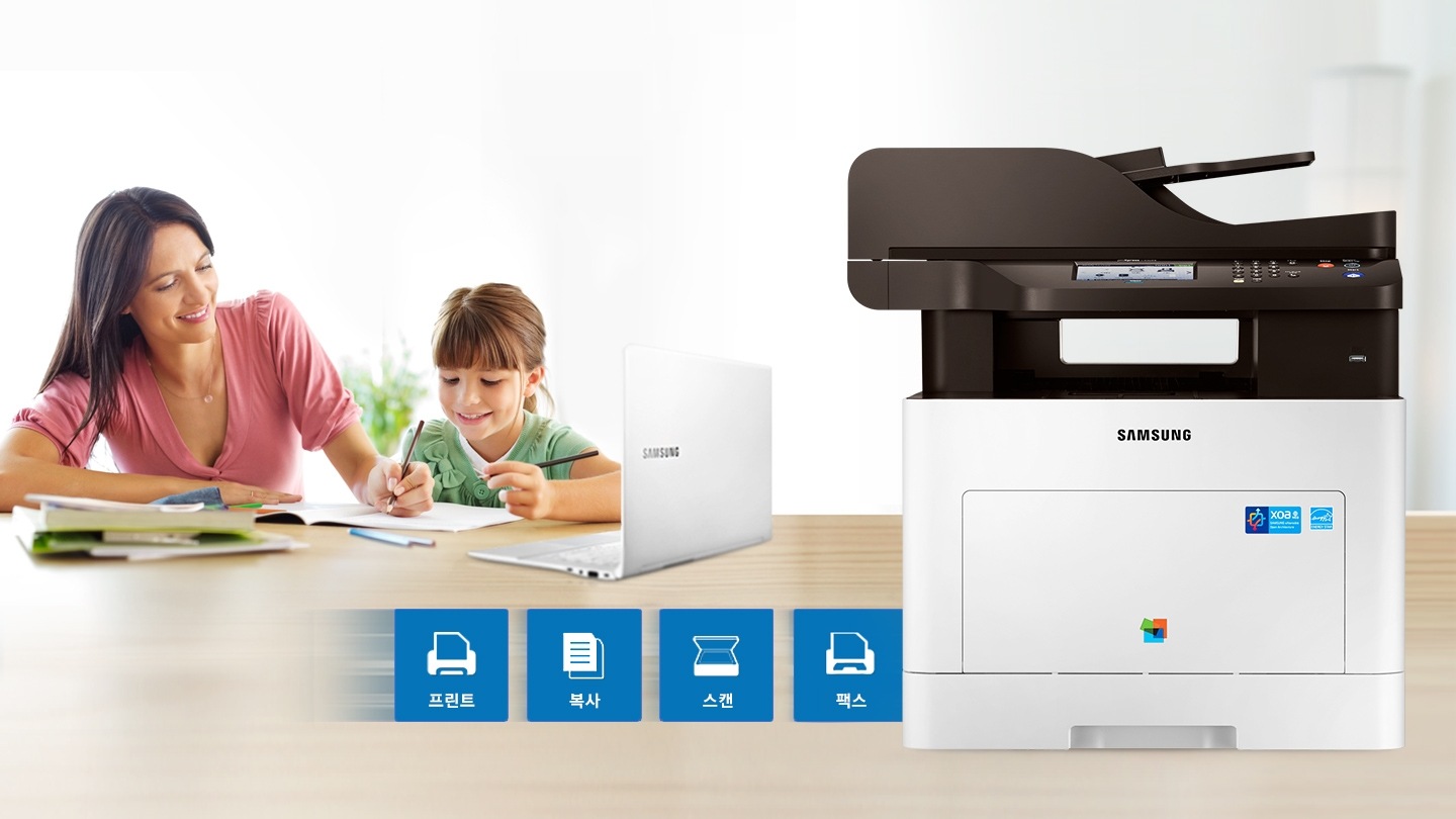 오른쪽에 SL-C3060FR 모델 있고 왼쪽에는 아이와 함께 학습하는 여자가 있으며, 프린터 옆에는 프린트, 복사, 스캔, 팩스 아이콘이 있다.