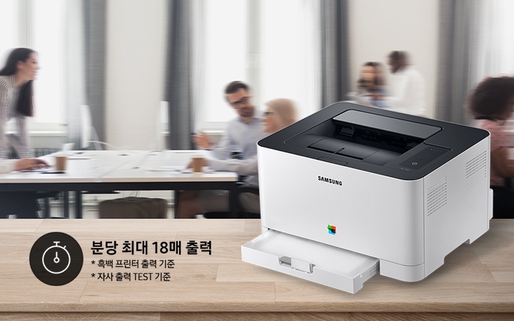 배경에는 바쁘게 회의를 하는 사람들의 모습, 바쁘게 지나가는 사람들의 모습이 흐릿하게 나와 있으며 이미지 오른쪽 부분에는 제품 오른쪽 위에서 내려본 이미지가 배치하여 있고이미지 왼쪽 하단에 분당 최대 18매 출력, * 흑백 프린터 출력 기준, 자사 출력 TEST 기준 텍스트가 쓰여 있으며, 타이머 아이콘이 나와있습니다.