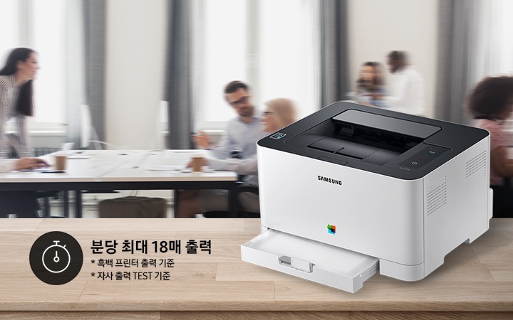 배경에는 바쁘게 회의를 하는 사람들의 모습, 바쁘게 지나가는 사람들의 모습이 흐릿하게 나와 있으며 이미지 오른쪽 부분에는 제품 오른쪽 위에서 내려본 이미지가 배치하여 있고이미지 왼쪽 하단에 분당 최대 18매 출력, * 흑백 프린터 출력 기준, 자사 출력 TEST 기준 텍스트가 쓰여 있으며, 타이머 아이콘이 나와있습니다.