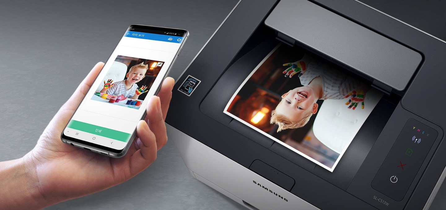 검정 색상의 나무 책상에 제품의 왼쪽 위에서 내려본 이미지가 있고 스마트폰을 제품 이미지 상단에 NFC 태그 스티커가 붙어있는 부분에 태그하는 이미지입니다.