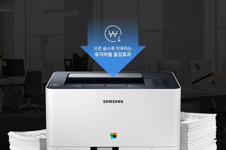 컬러 레이저프린터 18/4 ppm 화이트 제품 정면 모습과 주변에는 용지들이 쌓여있는 이미지 입니다. 상단에는 쓰면 쓸수록 만족하는 유지비용 절감효과라고 적혀있습니다.