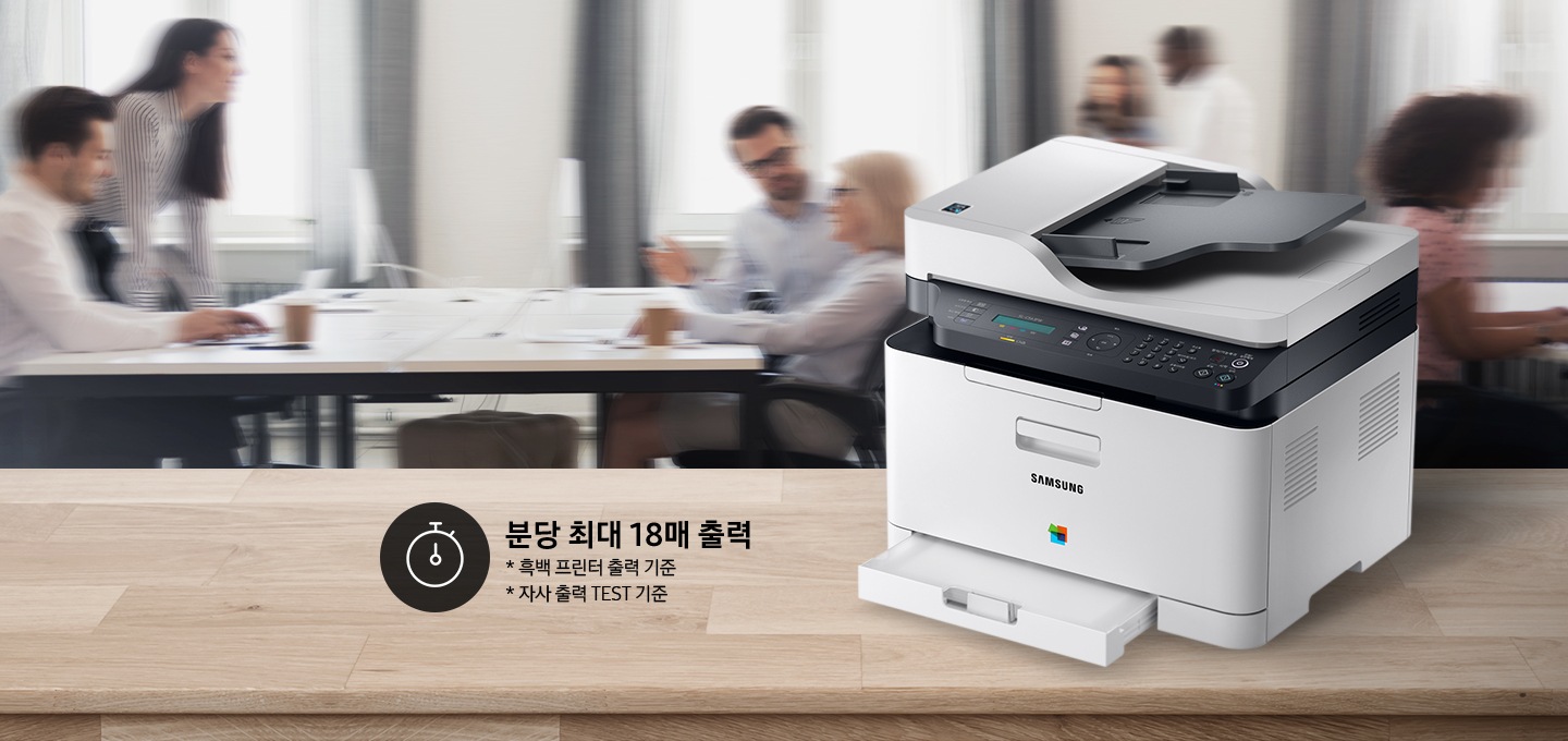 배경에는 바쁘게 회의를 하는 사람들의 모습, 바쁘게 지나가는 사람들의 모습이 흐릿하게 나와 있으며 이미지 오른쪽 부분에는 제품 오른쪽 위에서 내려본 이미지가 배치하여 있고이미지 왼쪽 하단에 분당 최대 18매 출력, * 흑백 프린터 출력 기준, 자사 출력 TEST 기준 텍스트가 쓰여 있으며, 타이머 아이콘이 나와있습니다.