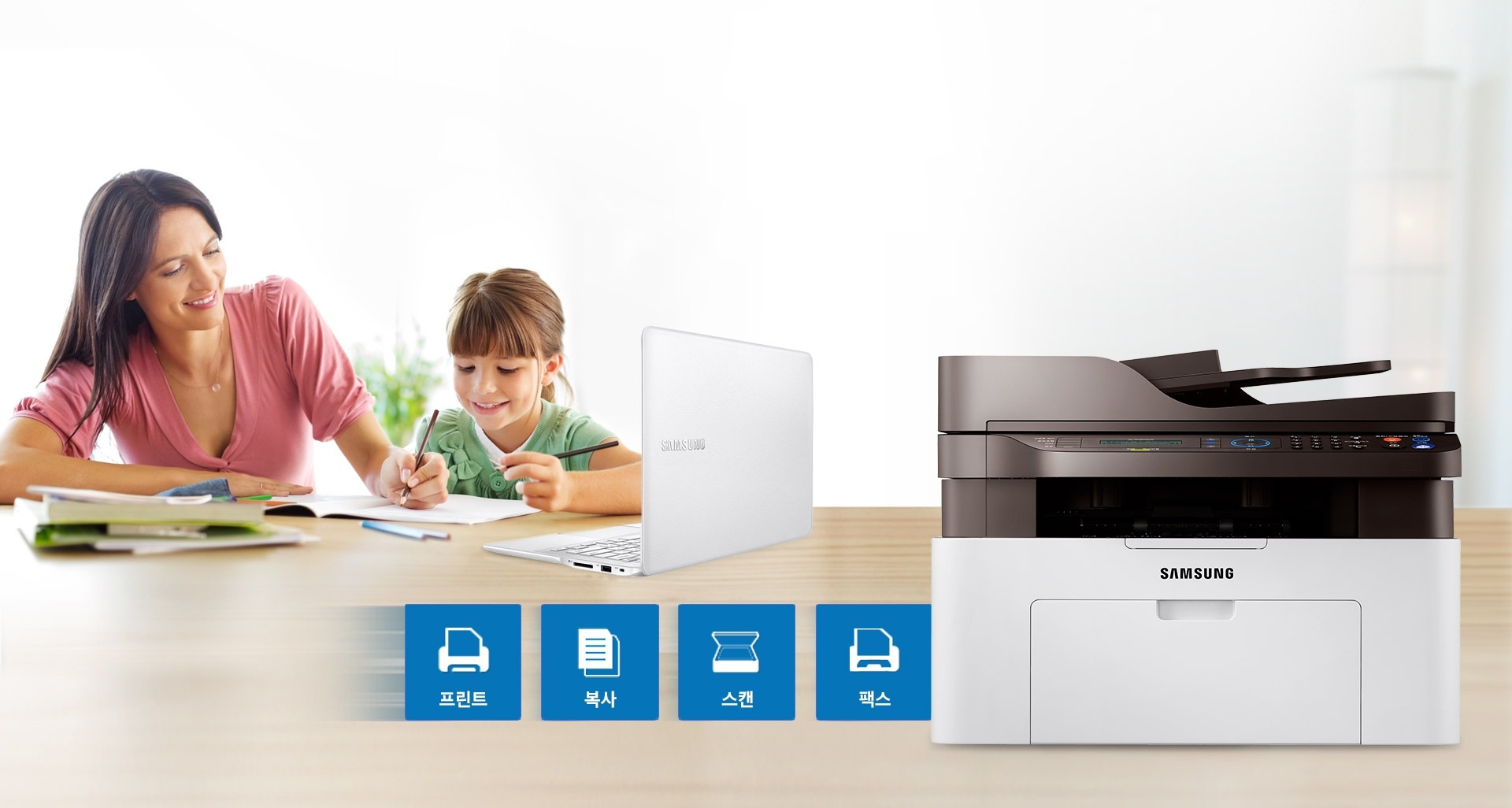 오른쪽에 SL-M2077F모델 있고 왼쪽에는 아이와 함께 학습하는 여자가 있으며, 프린터 옆에는 프린트, 복사, 스캔, 팩스 아이콘이 있다.