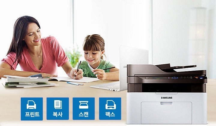 여성과 여자 아이가 색칠 공부를 하는 모습과 프린터, 복사, 스캔, 팩스 기능을 가지고 있는 삼성 SL-M2078FW를 보여주고 있습니다.
