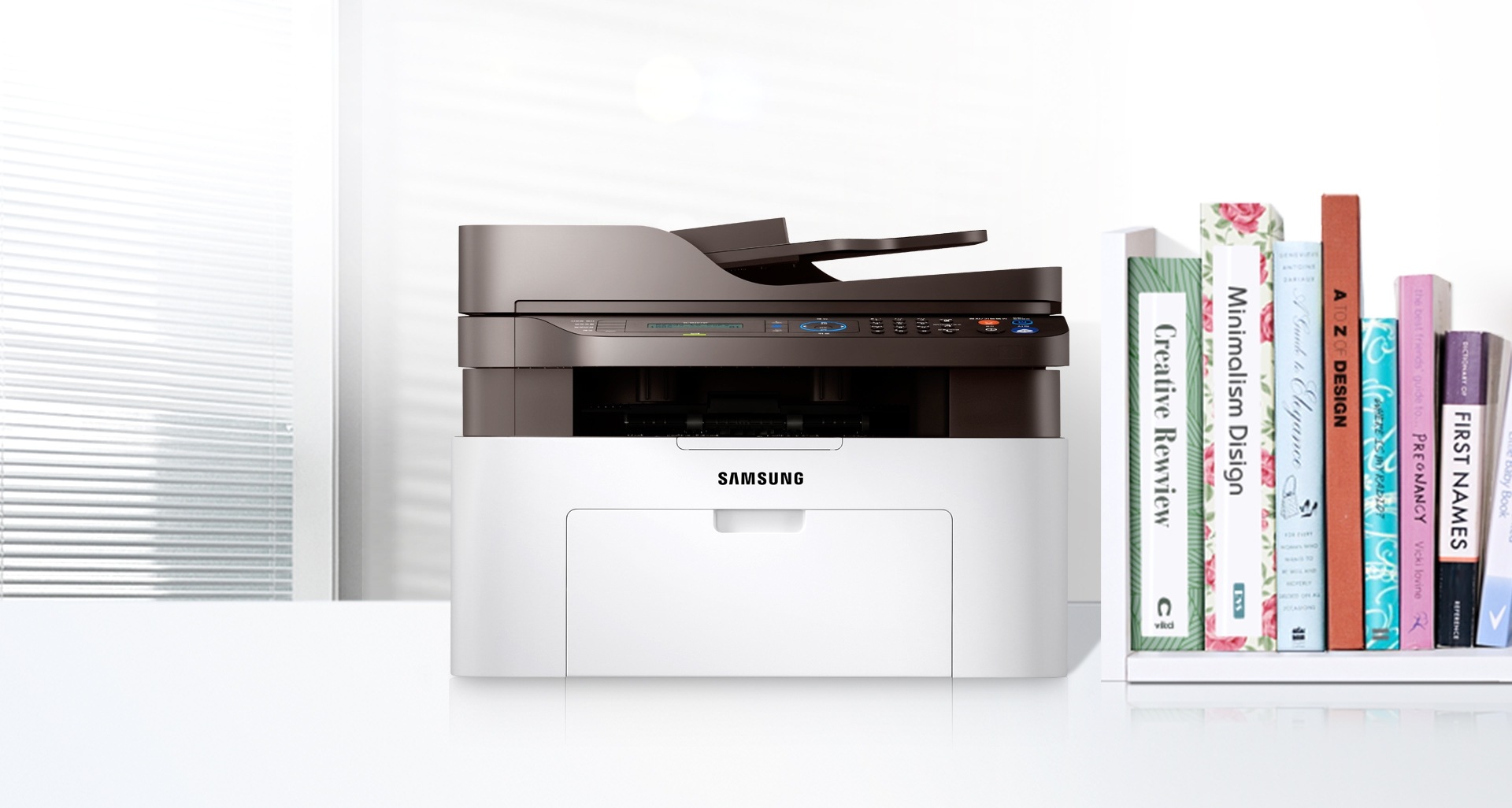 좌측에는 SL-M2079F 모델이 있고 오른쪽에는 책이 꽂혀져 있다.