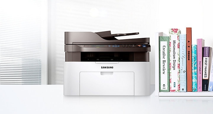 좌측에는 SL-M2079F 모델이 있고 오른쪽에는 책이 꽂혀져 있다.