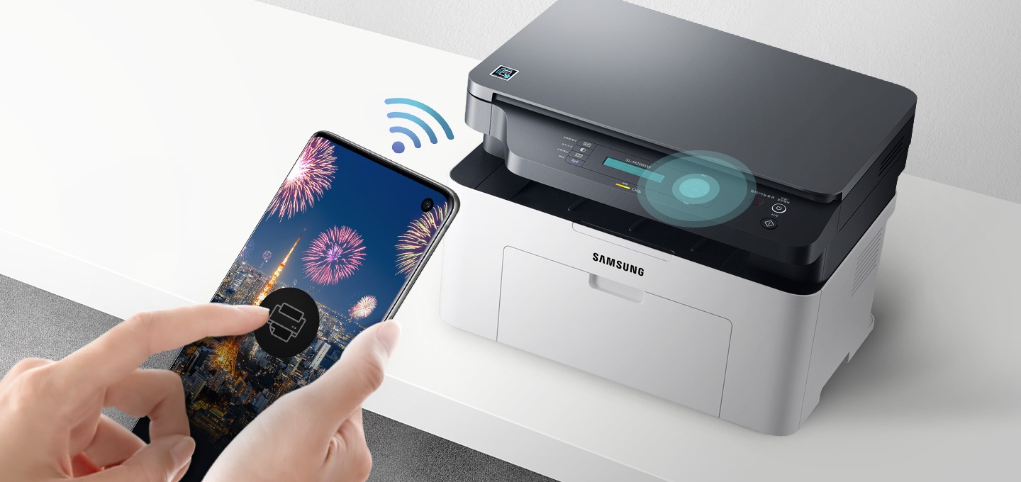 하얀색 책상 위에 제품을 오른쪽 위에서 내려본 이미지가 중간에 배치하여 있고 이미지 왼쪽 부분에 스마트폰 화면에 프린터 아이콘을 누르고 있는 사람의 손이 배치하여 있습니다.