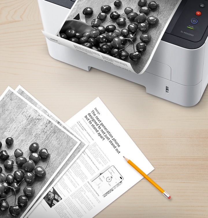 나무 책상 위 배경에 오른쪽 위에는 출력물이 출력되고 있는 제품을 위에서 내려본 이미지가 있고 출력물은 안쪽 부분에 텍스트가 있는것이 보여지고 있어 양면으로 인쇄를 할 수 있는 것을 알려주고있습니다. 이미지 왼쪽 하단에는 이미 출력된 출력물이 나열되어 있습니다.