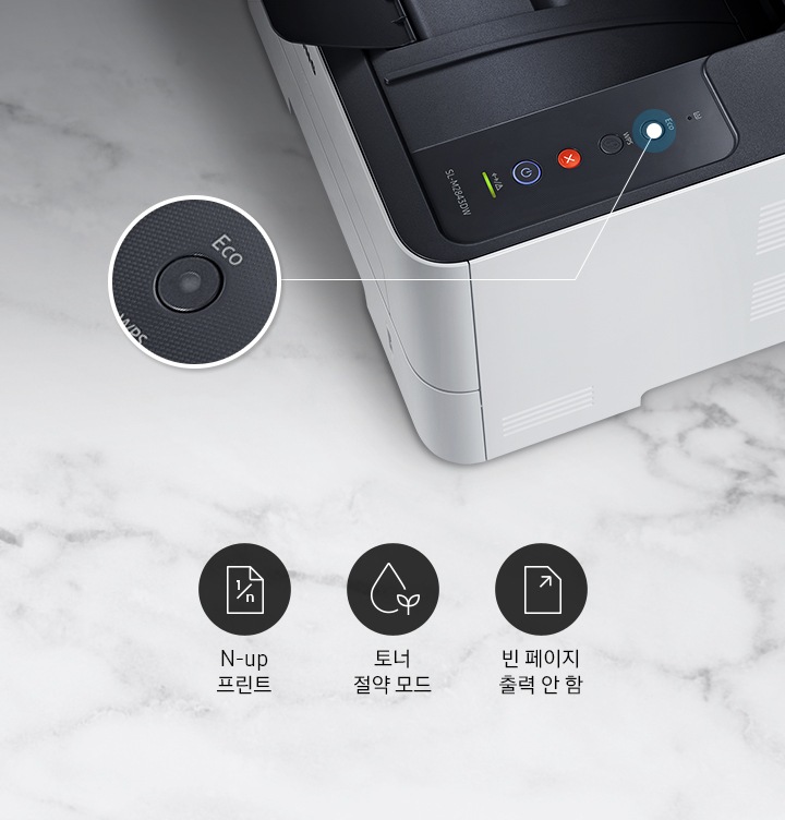 하얀 대리석 바닥에 이미지 오른쪽 위 부분에는 위에서 내려본 제품 이미지가 있고 제품 이미지에서 ECO 부분은 제품 이미지 왼쪽에 확대하여 보여주고 있습니다. 이미지 왼쪽 하단에는 N-up 프린트, 토너 절약 모드, 빈 페이지 출력 안 함 텍스트가 왼쪽에서 오른쪽으로 나열하여 있습니다.