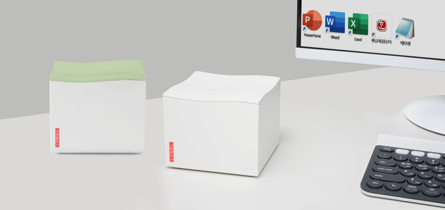 컴퓨터옆에 라벨프린터가 놓여져 있습니다.